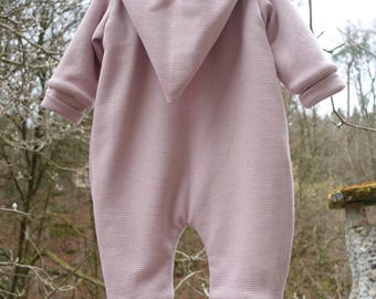 Peut inclure: Une grenouillère rose pour bébé avec une capuche. La grenouillère est faite d'un tissu doux et texturé.