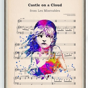 May include: A framed art print displaying sheet music with the title "Castle on a Cloud" from Les Misérables. The artwork features a watercolour portrait of a young girl in shades of blue, purple, and yellow, set against a backdrop of musical notation.