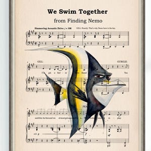 Può includere: Stampa incorniciata con spartito musicale e un'illustrazione ad acquerello di un pesce di Alla ricerca di Nemo. Il testo "We Swim Together" è visualizzato sopra il pesce. Il pesce è principalmente nero, giallo e bianco.