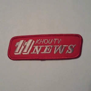 May include: Red embroidered patch with white lettering that reads "11 KHOUT-TV NEWS".