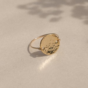 Peut inclure: Une bague en or avec un cercle martelé et une surface texturée.