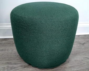 May include: A dark green round ottoman with a textured fabric cover.