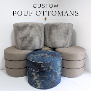 May include: Five cylindrical pouf ottomans arranged in a group. Two feature a grey and white houndstooth pattern, two are solid tan with horizontal piping, and one is dark blue with a floral print. The text CUSTOM POUF OTTOMANS is above.