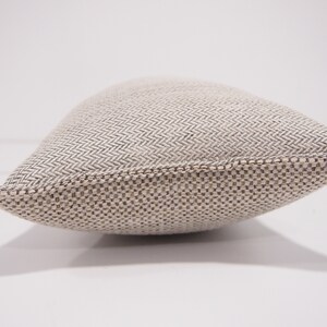 May include: A beige and brown rectangular pillow with a woven herringbone pattern.