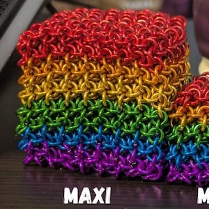 Puede incluir: Tres cubos de cota de malla de colores del arco&iacute;ris en varios tama&ntilde;os: Maxi, Midi y Mini. Los cubos est&aacute;n dispuestos en un degradado de colores, del rojo al morado. El texto "MAXI CUBE", "MIDI CUBE" y "MINI CUBE" est&aacute; debajo de cada cubo.