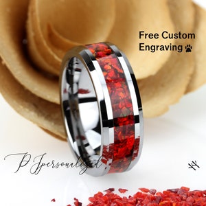 May include: A silver tungsten carbide ring with a red inlay. The ring has a beveled edge and a polished finish. Free custom engraving is available.