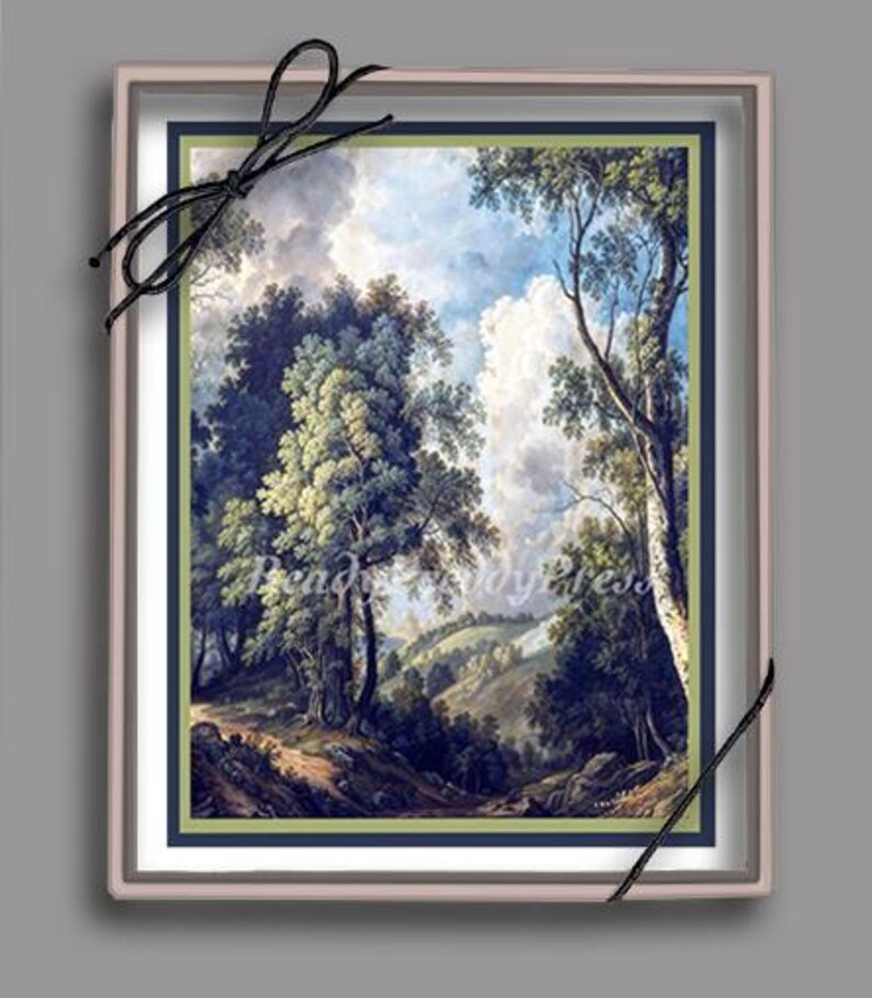 May include: A framed landscape painting depicting a lush green forest with a winding path leading through the trees. The sky is a bright blue with fluffy white clouds. The painting is in a light pink frame with a dark blue mat.