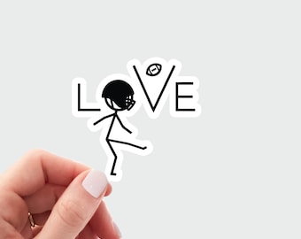 May include: A black and white sticker with a stick figure football player kicking a football towards the word "LOVE".