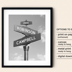 May include: Black and white photo of a street sign with the names "Robinson" and "Campbell" on it. The year "2014" is on the top of the sign. The sign is framed in a black frame.