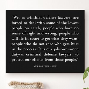 May include: A black framed print with white text. The text reads, "We, as criminal defense lawyers...protect our clients from those people." A straw hat, pillow, and book sit on a bench below the print. A potted plant is to the right.
