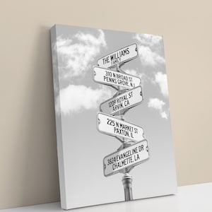 May include: Black and white image of a street sign with the text "THE WILLIAMS FAMILY" and five additional street signs with addresses and locations. The signs are arranged in a spiral pattern.