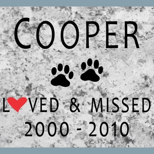 May include: A black and white memorial plaque with the name "COOPER" in large letters, two black paw prints, a red heart, and the text "LOVED & MISSED 2000-2010".