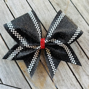 May include: Black and white checkered glitter bow with a red rhinestone center.