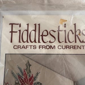 K&ouml;nnte beinhalten: Ein Bastelset mit dem Text "Fiddlesticks CRAFTS FROM CURRENT". Das Set zeigt ein Kreuzstichdesign einer roten und gr&uuml;nen Weihnachtssternblume. Das Set befindet sich in einer transparenten Kunststoffverpackung.