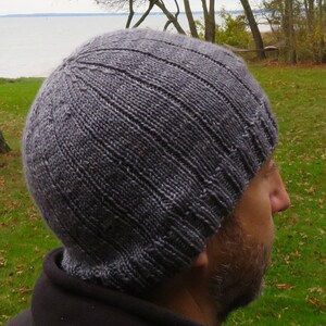 Puede incluir: Un gorro de punto gris con textura de canal&eacute;. El gorro lo lleva puesto una persona con barba.