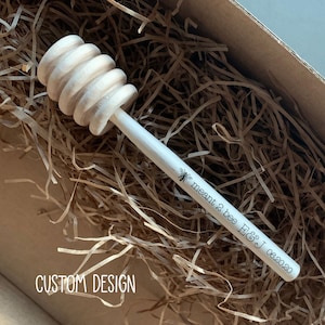 May include: A wooden honey dipper with a bee design and the text "meant 2 bee E&J 06.2020".