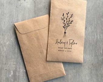 May include: Two brown paper envelopes with a floral design and the text "Haley & Tyler Tying the Knot August 1, 2020".