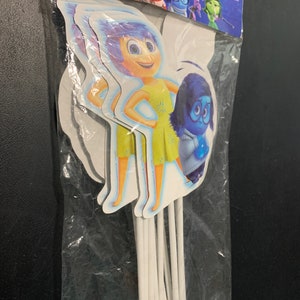 May include: A package of 8 Inside Out character cake toppers. The toppers feature Joy and Sadness from the Disney Pixar movie. The toppers are printed on cardstock and attached to white sticks.