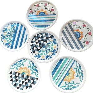 May include: Six ceramic plates with different blue, white, and green geometric and floral patterns. The plates are all round and have a white background.