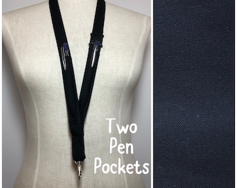 May include: Black lanyard with two pen pockets and a silver clip. The text "Two Pen Pockets" is printed on the lanyard.