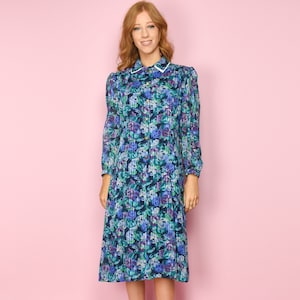 May include: A blue and green floral print midi dress with a white collar and long sleeves. The dress has a button-up front and a slightly flared skirt.