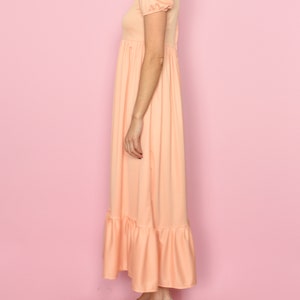 May include: A peach-colored maxi dress with short puff sleeves and a tiered skirt.
