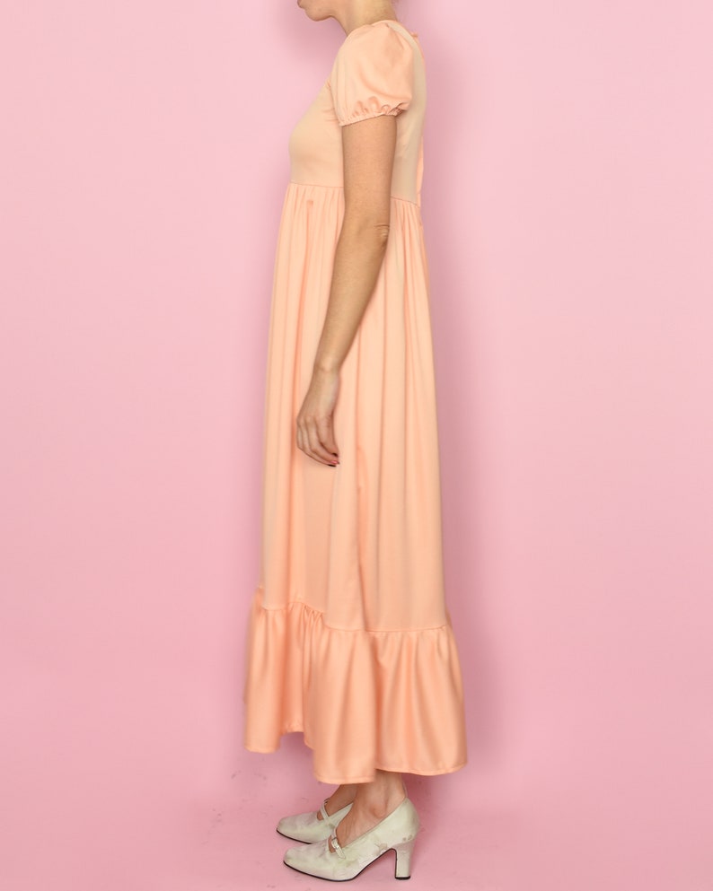 May include: A peach-colored maxi dress with short puff sleeves and a tiered skirt.