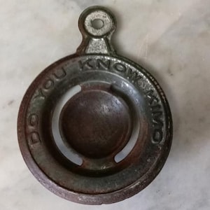 May include: A vintage metal egg separator with a handle. The separator has a circular design with the words "Do You Know" inscribed around the edge.