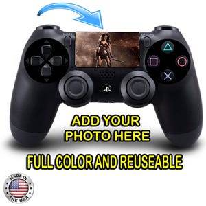 May include: Black PlayStation 4 controller with a clear plastic skin featuring a Wonder Woman image. The skin is reusable and full color. The text "ADD YOUR PHOTO HERE" is printed below the controller.