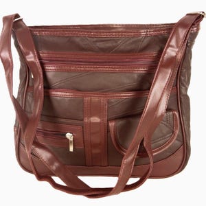 May include: A brown shoulder bag with multiple compartments and a long strap. The bag features a quilted design on the main body and several zippered pockets. The bag has a shiny finish and a gold-colored zipper.