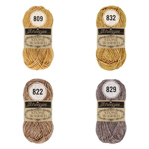 Könnte beinhalten: Vier Knäuel Scheepjes Stone Washed Garn in verschiedenen Farben: 809 Gold, 832 Gold, 822 Braun und 829 Grau.