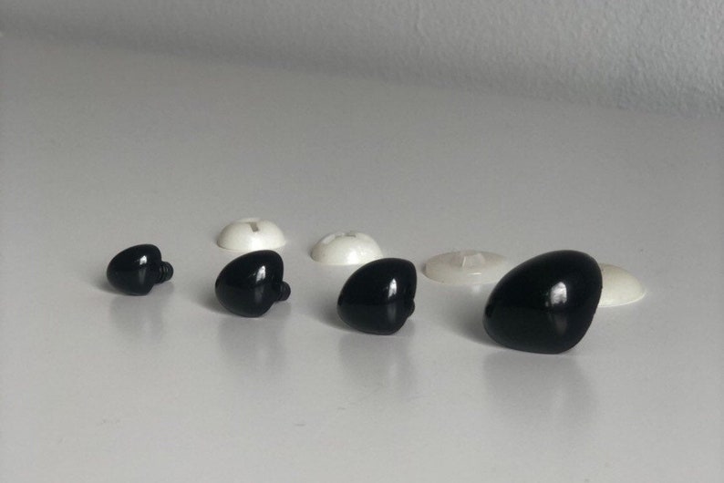 May include: Assortment of black plastic safety eyes for crafts. The eyes come in various sizes and have a flat back with a small screw post.