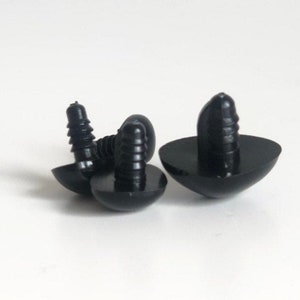 May include: Three black plastic safety eyes with a screw-on back. The eyes are different sizes and have a shiny finish.