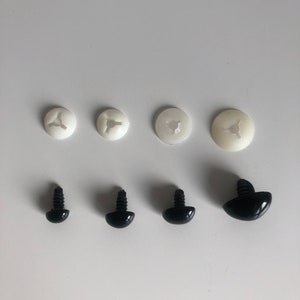 May include: Assortment of black plastic safety eyes for crafts. The eyes come in three sizes and have a screw-on back. There are also four white plastic washers.