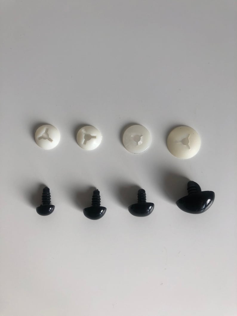 May include: Assortment of black plastic safety eyes for crafts. The eyes come in three sizes and have a screw-on back. There are also four white plastic washers.