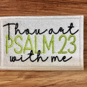 May include: White embroidered patch with green and black lettering that reads "Thou art PSALM 23 with me".