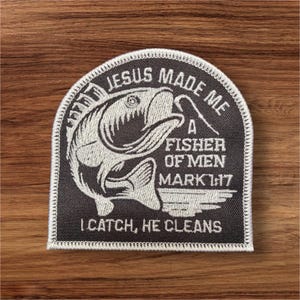 May include: A black and white embroidered patch with a fish and the text "Jesus Made Me A Fisher Of Men Mark 1:17 I Catch, He Cleans".