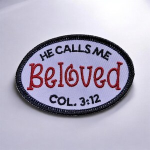 May include: Oval patch with the embroidered text "HE CALLS ME Beloved" in red script, with "COL. 3:12" below. The patch has a white background, black border, and is likely for clothing or accessories.
