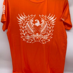 May include: Orange short-sleeved t-shirt with a white eagle graphic and the text "THE QUIET PROFESSIONALS" and "1918" printed on the shirt.