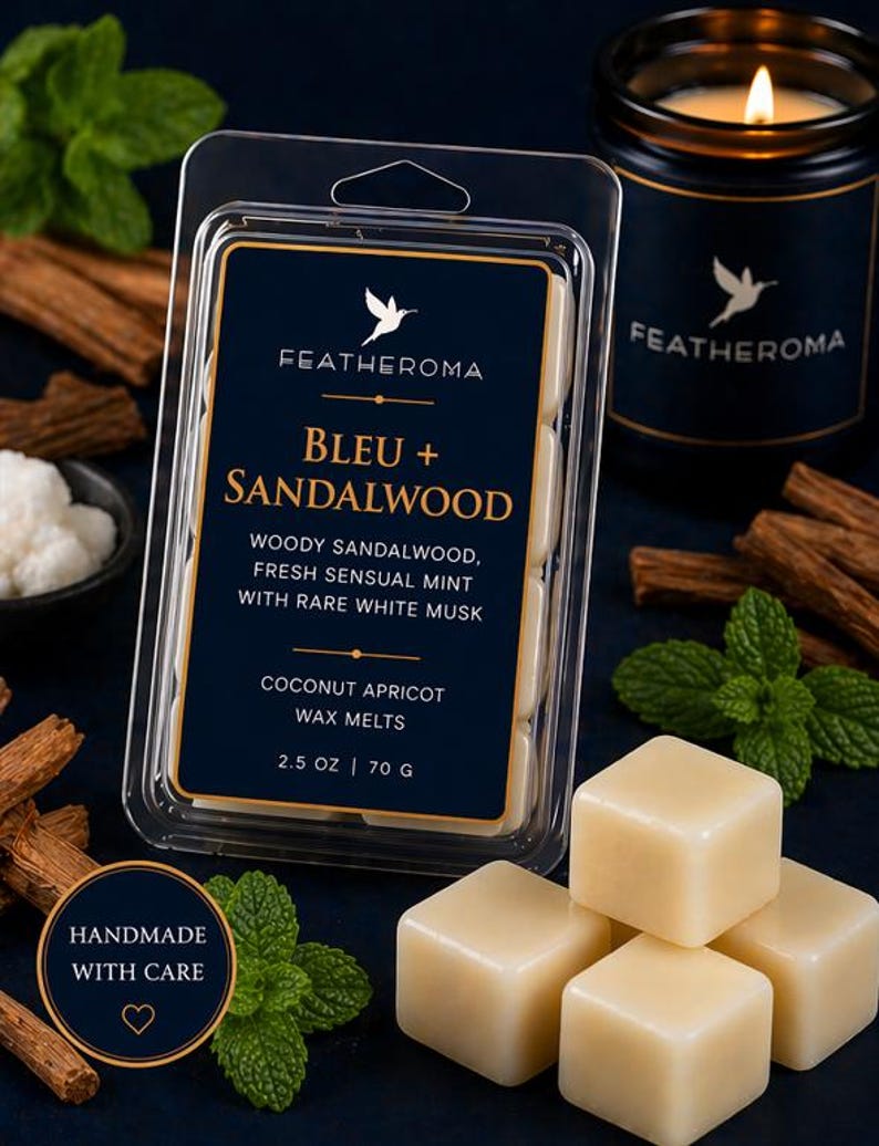 May include: A dark blue box of wax melts labeled "BLEU + SANDALWOOD" with the brand name "FEATHEROMA". The description includes "WOODY SANDALWOOD, FRESH SENSUAL MINT WITH RARE WHITE MUSK". A lit candle and sprigs of mint are also visible.