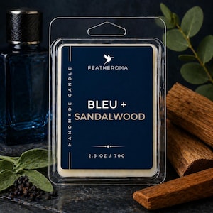 May include: A candle wax melt in a clear plastic clamshell package. The label is navy blue with the text "BLEU + SANDALWOOD" and "FEATHEROMA". The package contains 2.5 oz / 70g of wax. The background includes a blue bottle and wood pieces.