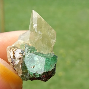 Puede incluir: Un grupo de cristales verdes y amarillos. Los cristales son translúcidos y tienen una variedad de formas y tamaños.