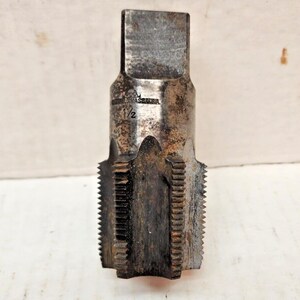 May include: A close-up of a rusty, metal tap and die with the text "1/2" and "ELDMASS" visible on the side.