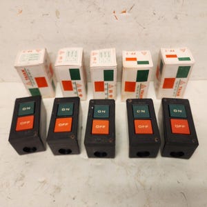 May include: Six black electrical switches with two buttons each. The buttons are labeled "ON" in green and "OFF" in orange. The switches are arranged in a row.