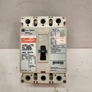 May include: A white Cutler-Hammer industrial circuit breaker with black and red labels. The breaker has an "On/Off" switch and a rating of 100 amps. The text "Made in U.S.A." is visible.