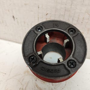 May include: A black and red pipe die with the text "RIDGID" and "1/4" printed on it.