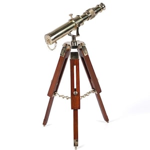 Pu&ograve; includere: Un telescopio in ottone con un treppiede in legno. Il telescopio &egrave; dorato e il treppiede &egrave; marrone scuro.