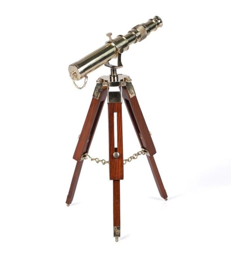 Pu&ograve; includere: Un telescopio in ottone con un treppiede in legno. Il telescopio &egrave; dorato e il treppiede &egrave; marrone scuro.