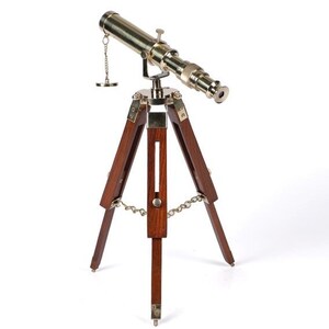 Pu&ograve; includere: Un telescopio in ottone con un treppiede in legno. Il telescopio &egrave; dorato e ha una catena attaccata ad esso. Il treppiede &egrave; in legno marrone scuro.