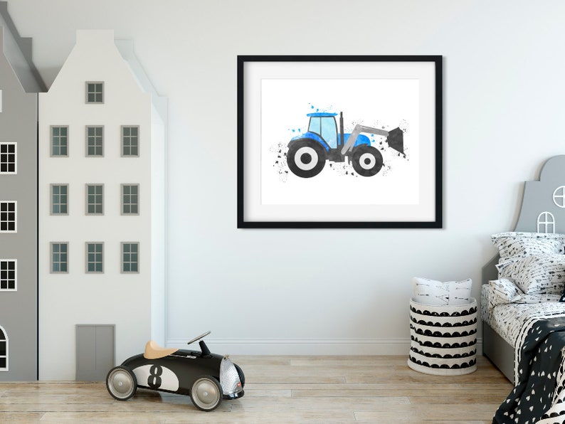 May include: A framed watercolor painting of a blue tractor with a black and white splatter background. The tractor is facing right and has a black bucket.